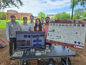 Group of people standing at table with their research on display.