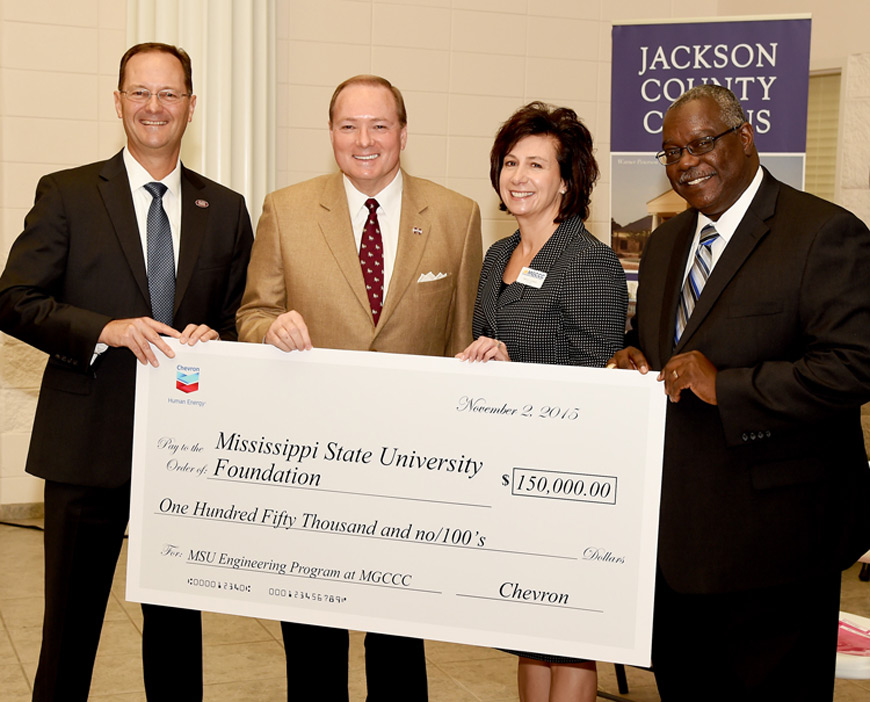 Mike Illanne, left, vice president of Chevron’s Gulf of Mexico Business Unit, and Bruce Chinn, right, general manager of Chevron’s Pascagoula Refinery, present a check accepted by MSU President Mark E. Keenum and MGCCC President Mary S. Graham. The $150,000 gift will support a new bachelor’s degree program in engineering offered through a MSU and MGCCC partnership. (Photo by Rich Kopp)